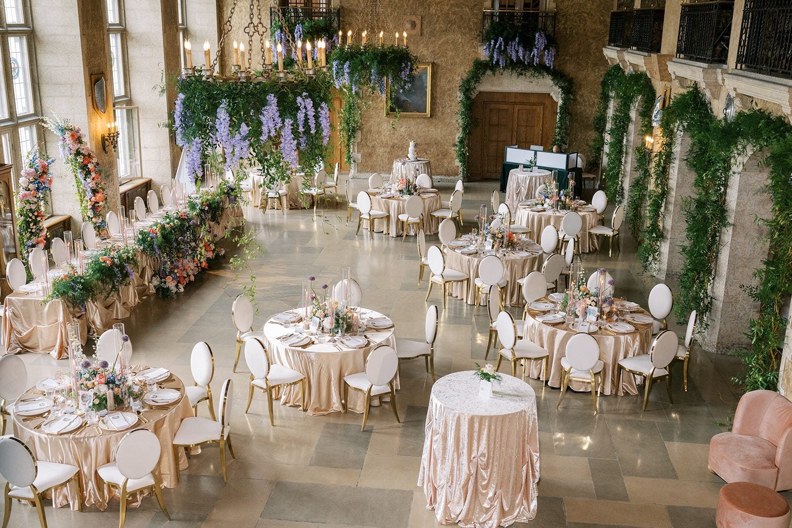 Lottie Mt. Stephen Hall wedding reception with champagne linens, garden inspired florals and greenery covered chandeliers.